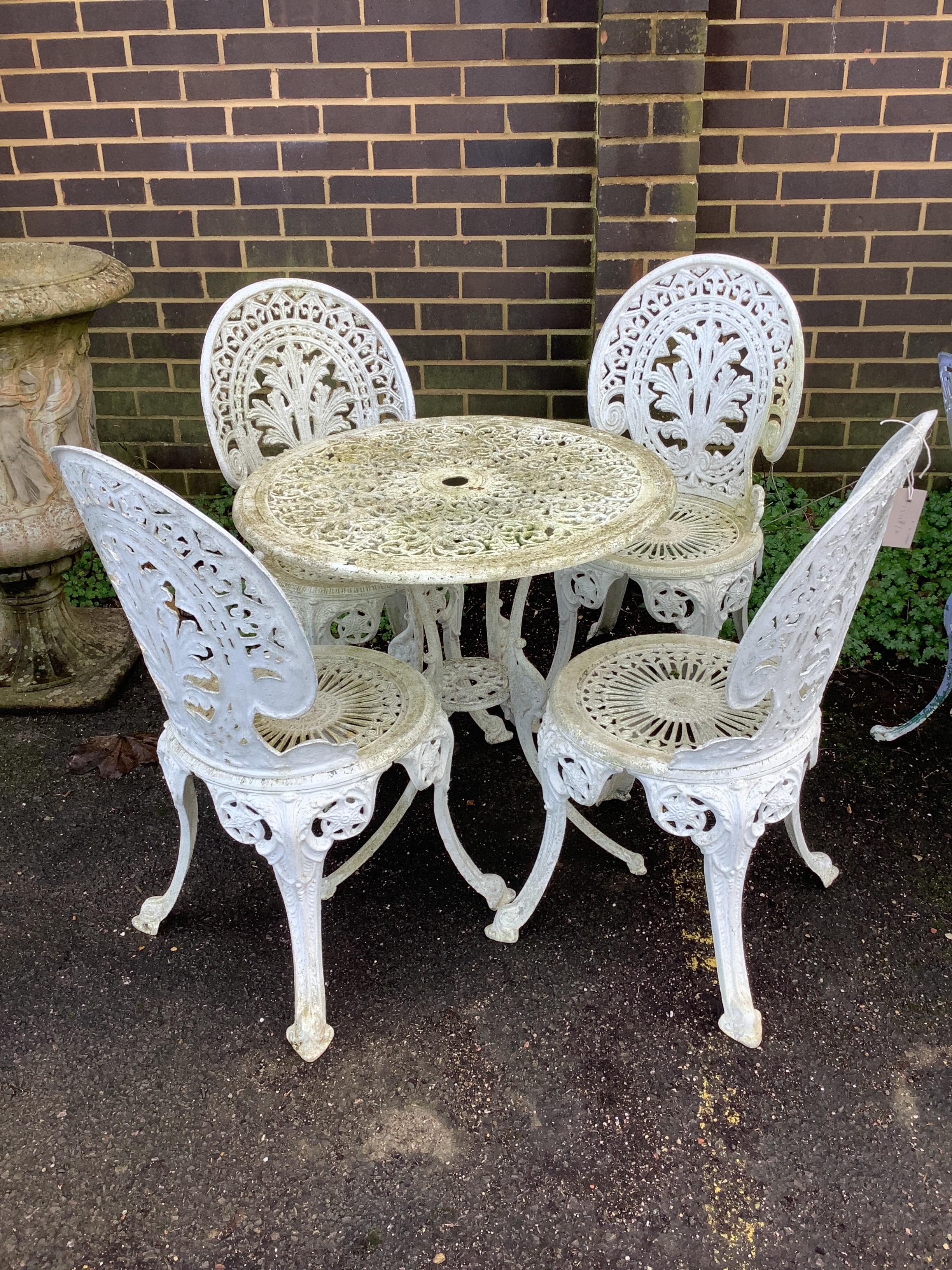 A Victorian style circular metal garden table, diameter 68cm, height 64cm, and four chairs